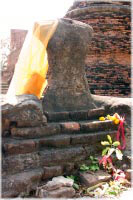 Torso einer Buddha-Statue mit Opfergaben im Wat Phra Sri Sanphet